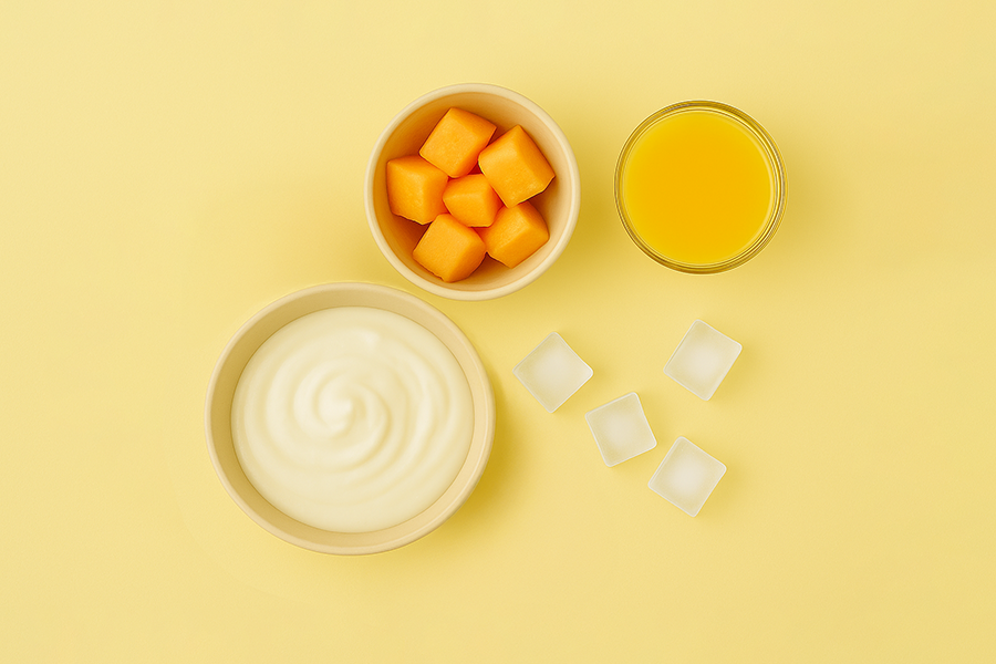 Yogurt, melon cubes, orange juice, and ice on yellow.