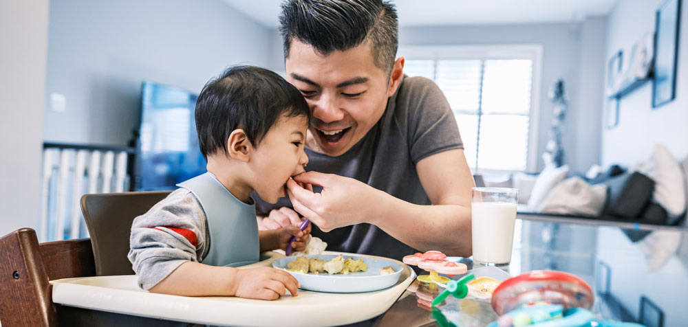 man and a child enjoying a meal together at a table