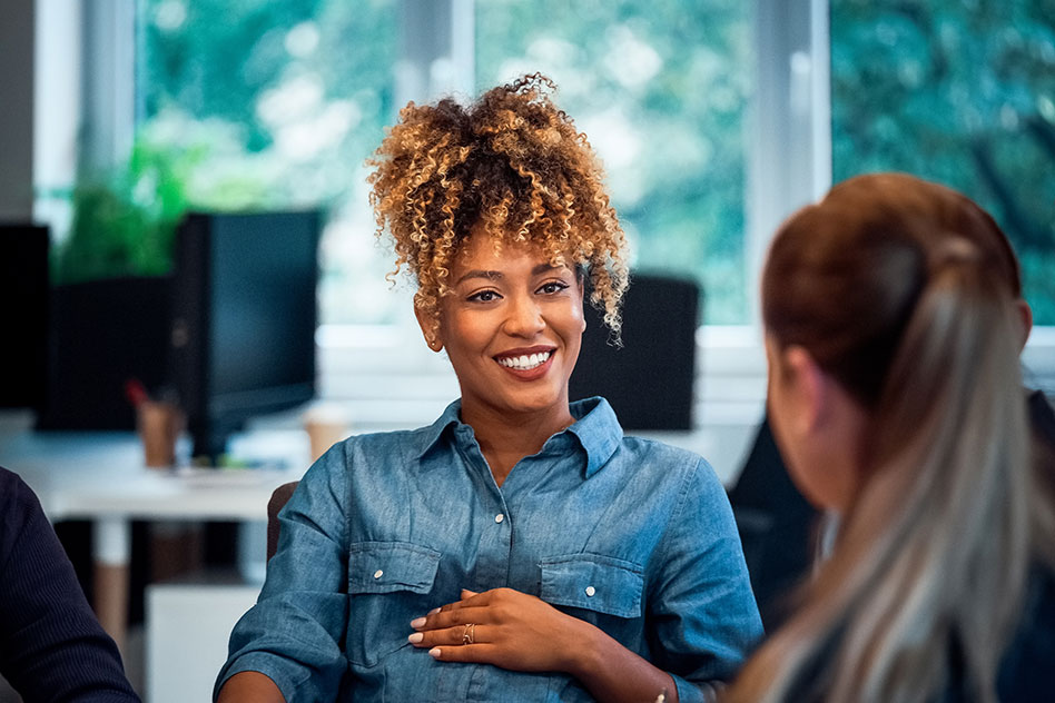 Smiling woman engages in conversation with colleague