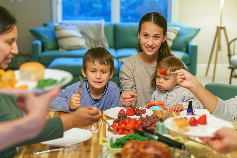 Family enjoying a meal, sharing food together happily.