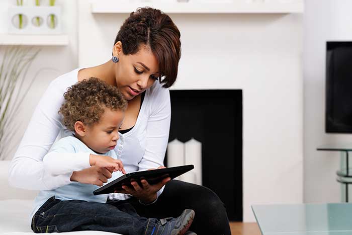 Parent and child reading on a tablet together.