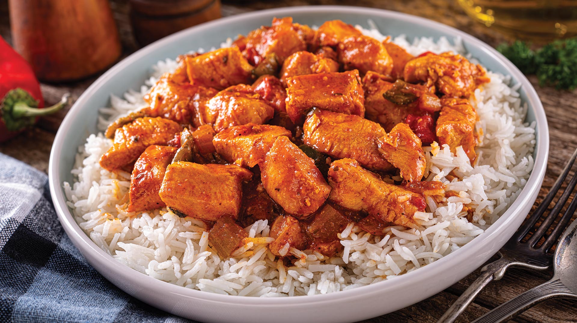 Spicy chicken served on white rice with sauce.